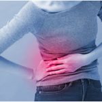 Woman holding her back indicating back pain.